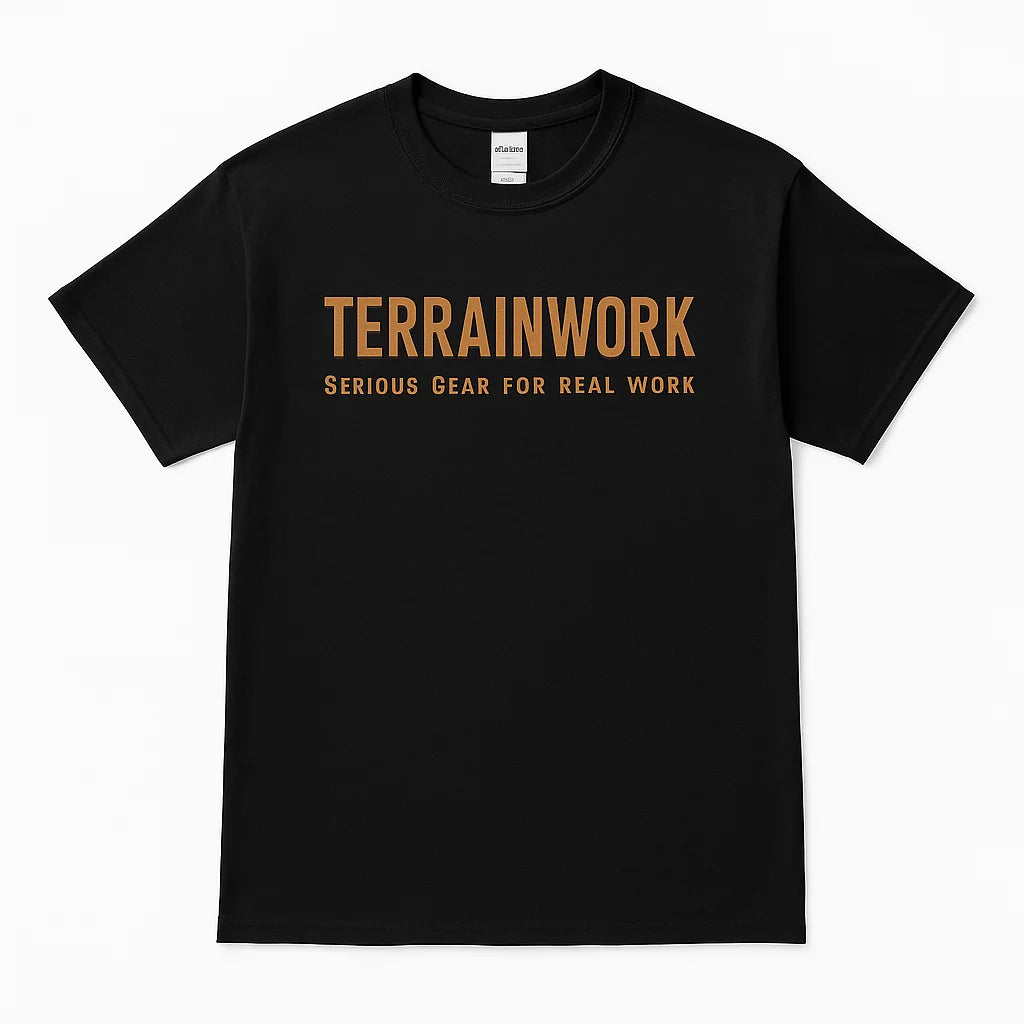Close-up detail of TERRAINWORK branding on the chest area of black cotton t-shirt, with visible stitching and texture