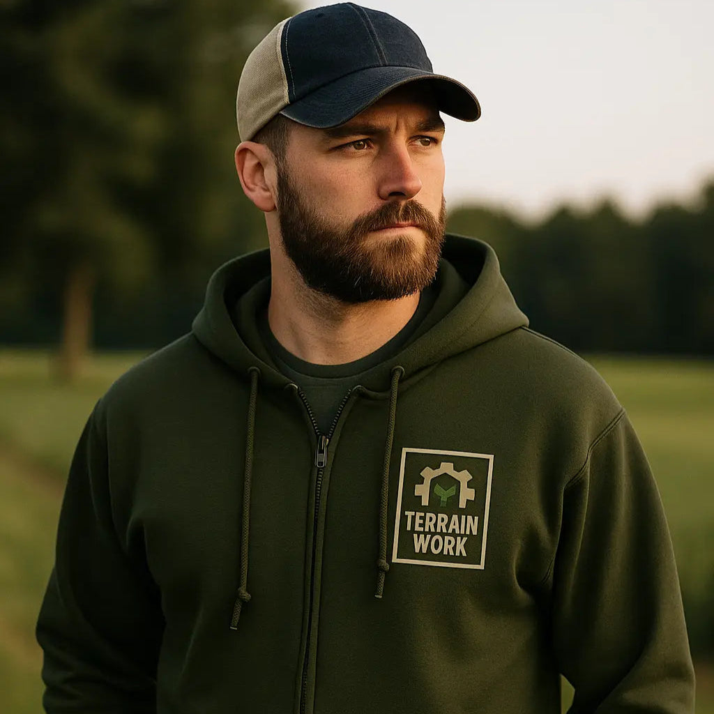 Close-up of embroidered TERRAINWORK chest logo on grey hoodie.	